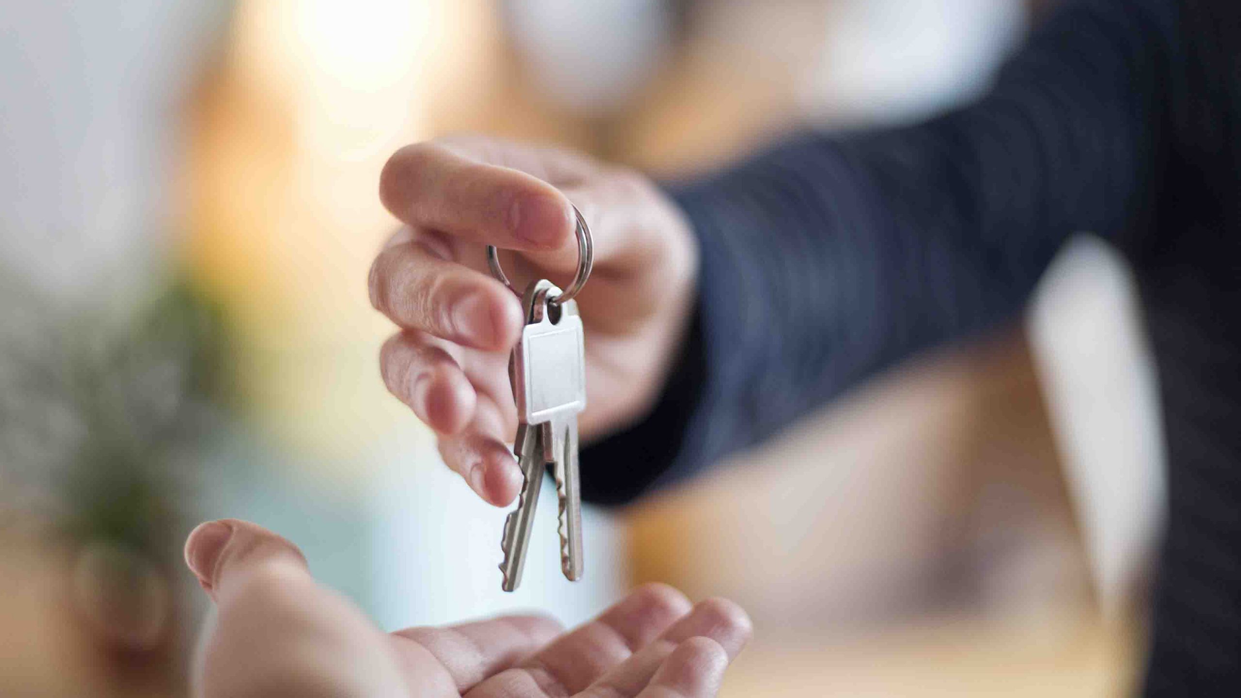 Close-up of hand over of house key in new home